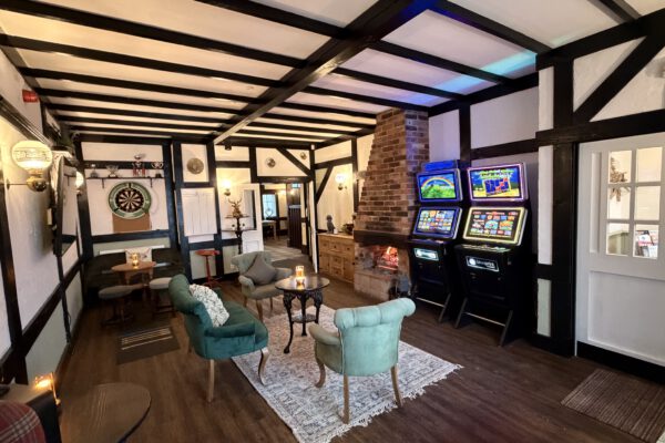 Traditional pub lounge with fireplace and games machines at The Horse and Jockey Bentley