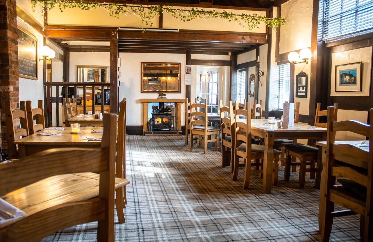 Barn restaurant dining space with brick walls at The Horse and Jockey Bentley